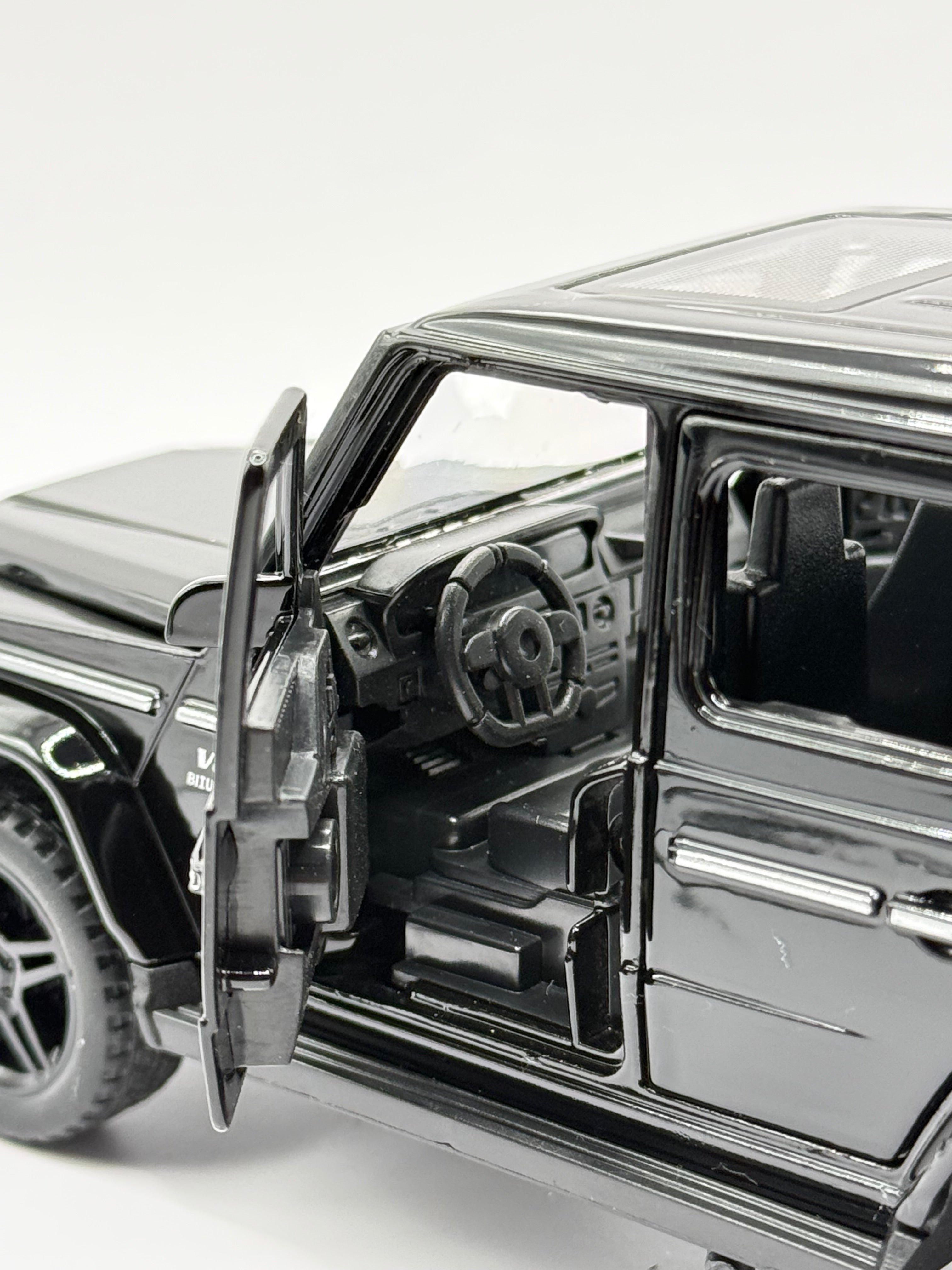 Close-up interior view through open driver door of 1:32 scale Mercedes G-Wagon showing detailed steering wheel.