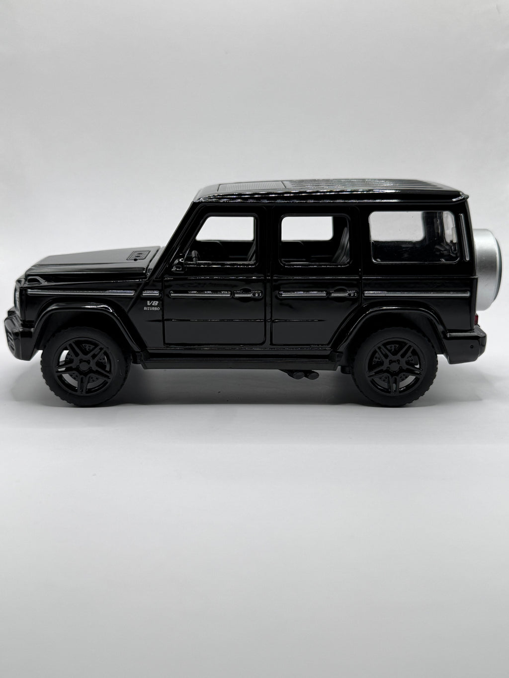 Side profile view of black 1:32 Mercedes G63 scale model car showing wheels and side trim.